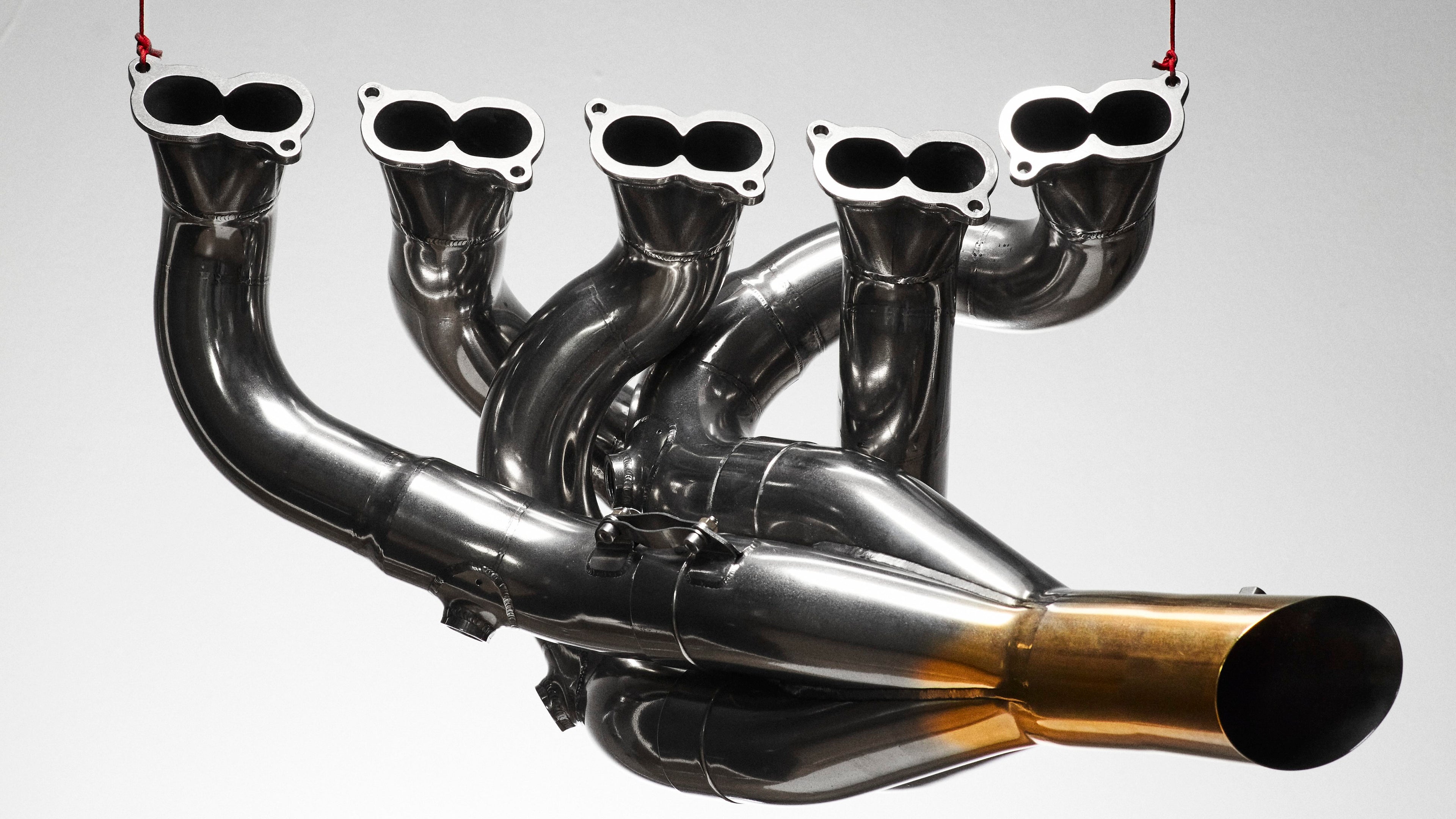 Close up of an F1 exhaust system hanging from red silk cord 