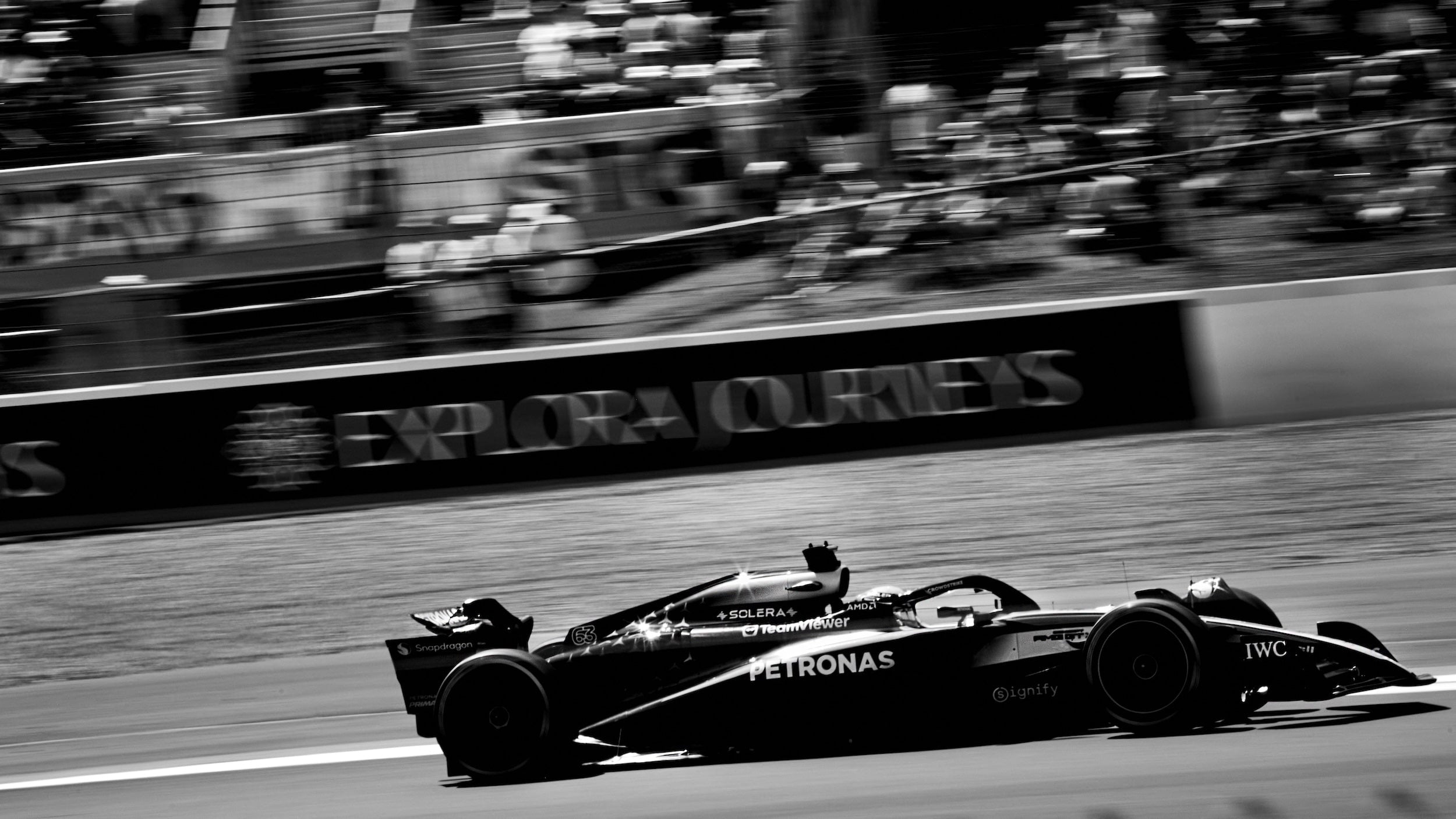 Mercedes Formula 1 car racing on a Silverstone Grand Prix circuit with a blurred background an fans during the British Grand Prix 2025